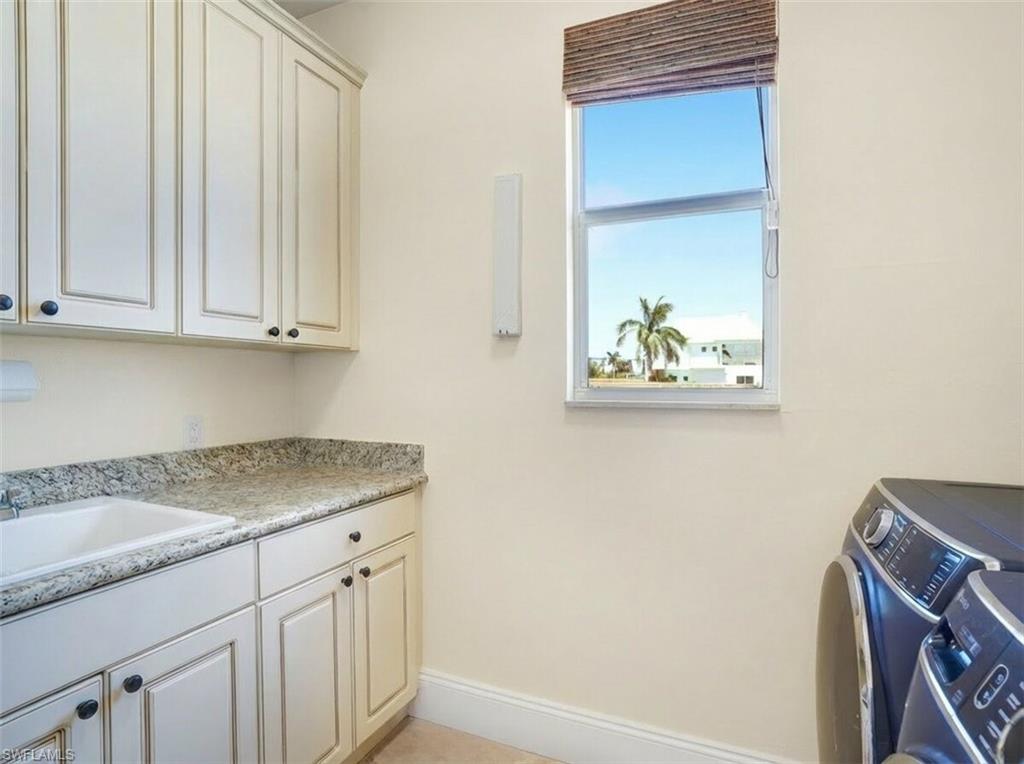 Laundry room featuring cabinet space and washer and dryer - Virtually Edited Image