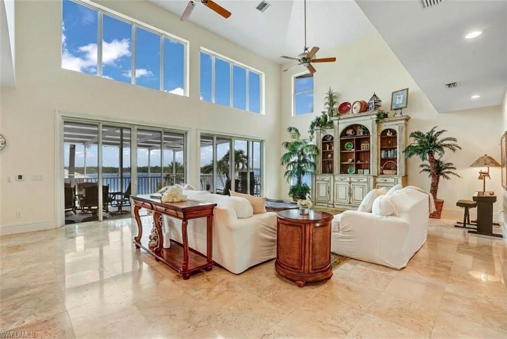 Living area featuring a high ceiling and ceiling fan - Virtually Edited Image