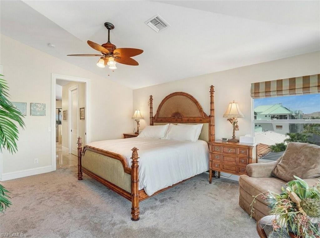 Carpeted bedroom featuring ceiling fan and lofted ceiling - Virtually Edited Image