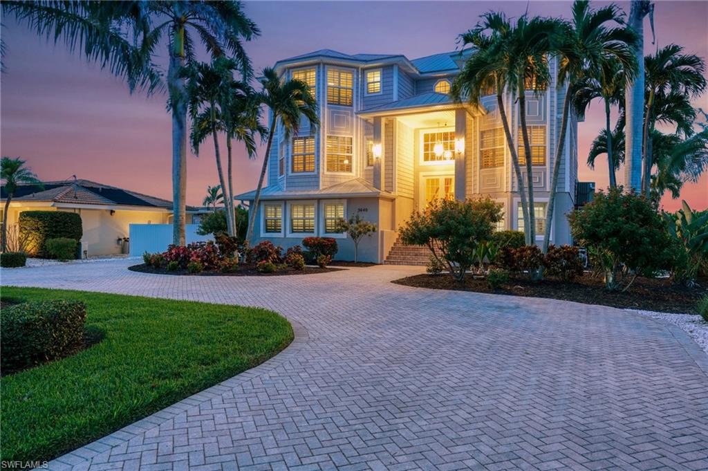 View of front of house featuring curved driveway, a front yard, and a standing seam roof - Virtually Edited Image
