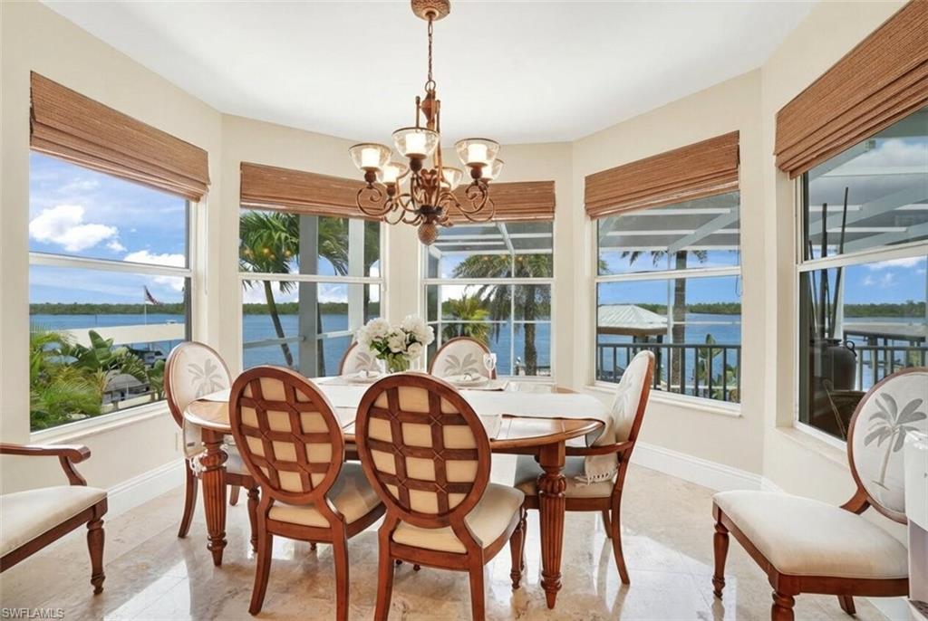 Sunroom / solarium with suspended lighting and a water view - Virtually Edited Image