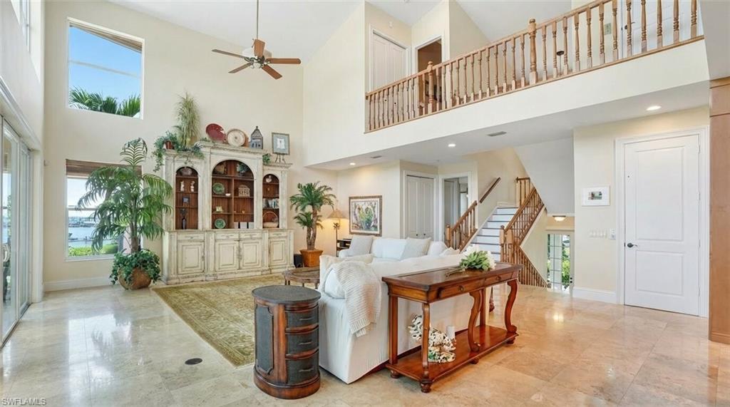 Living room featuring a high ceiling and ceiling fan - Virtually Edited Image