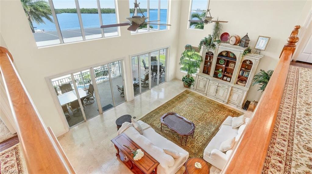 Living room featuring ceiling fan, a high ceiling, and french doors - Virtually Edited Image