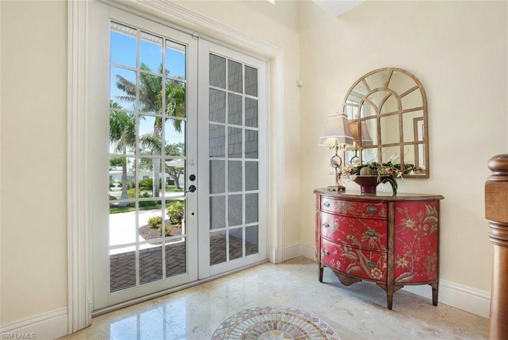 Doorway to outside featuring baseboards - Virtually Edited Image