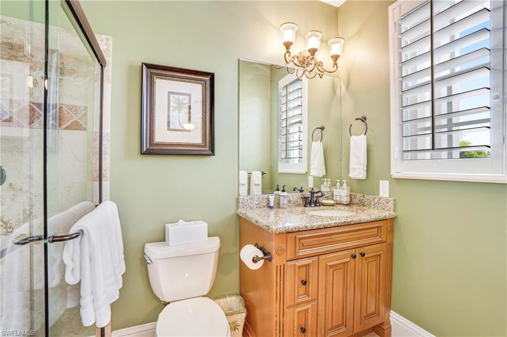 Bathroom featuring vanity, a shower stall, and suspended lighting - Virtually Edited Image