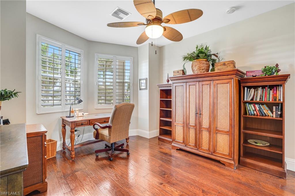 Office with dark wood-style flooring and a ceiling fan - Virtually Edited Image