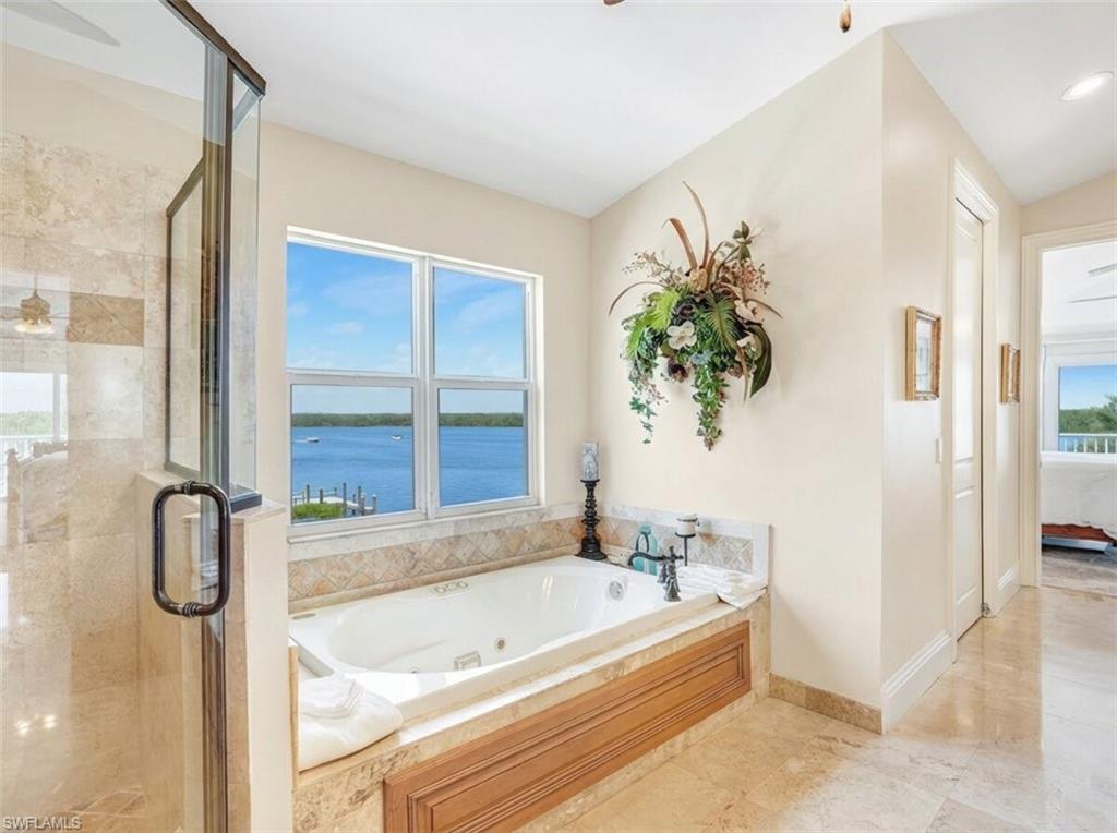 Bathroom with a ceiling fan, a stall shower, connected bathroom, and a tub with jets - Virtually Edited Image