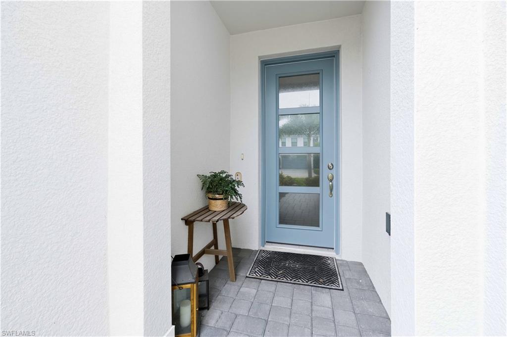 Doorway to property featuring stucco siding