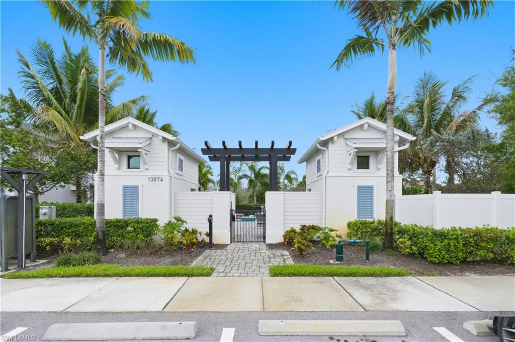 View of front facade featuring a gate, a pergola, and uncovered parking