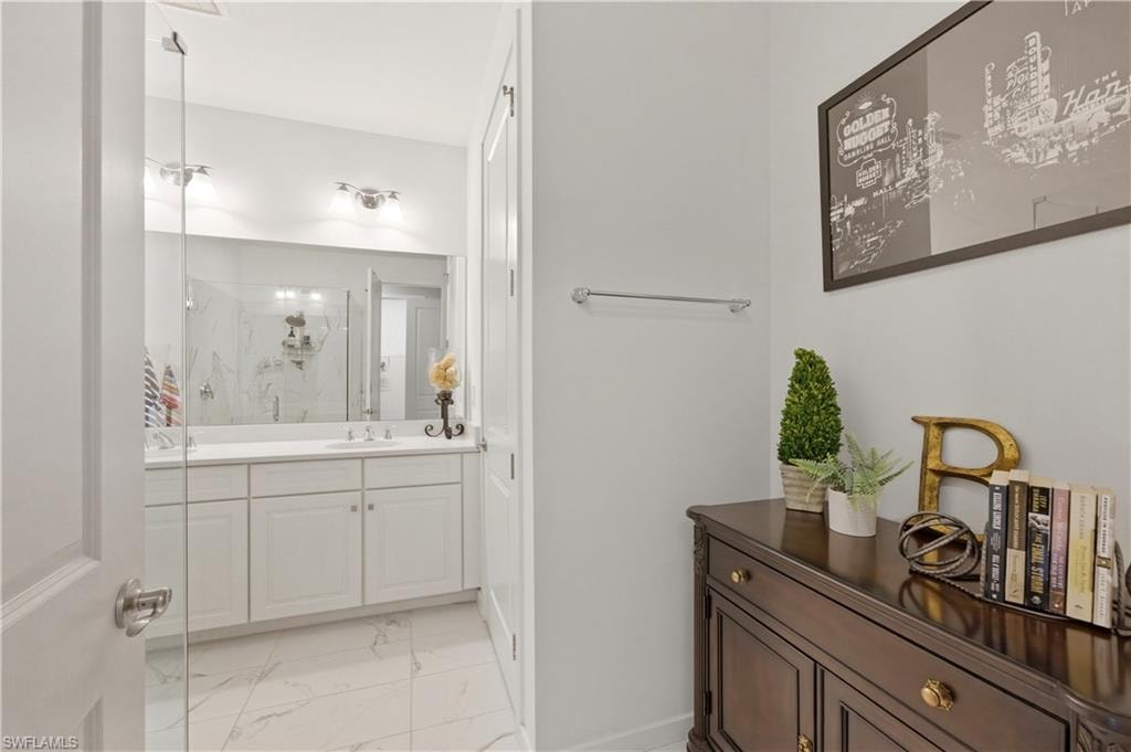 Full bathroom with a marble finish shower, vanity, and light marble finish flooring
