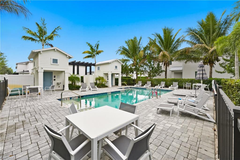 Community pool featuring outdoor dining space, a patio area, and a pergola