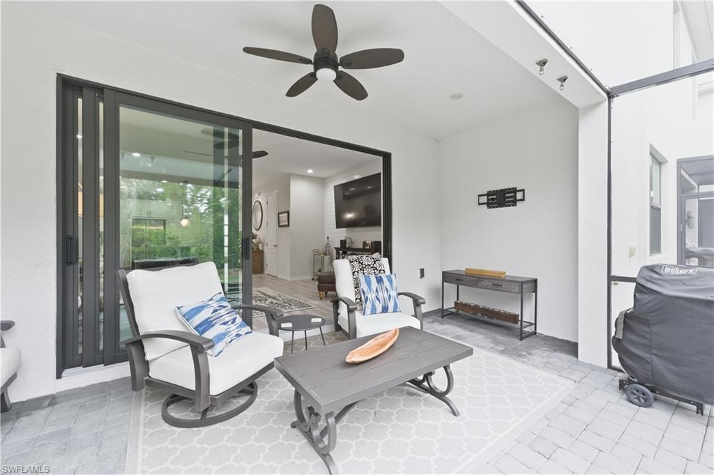 View of patio featuring ceiling fan and a lanai