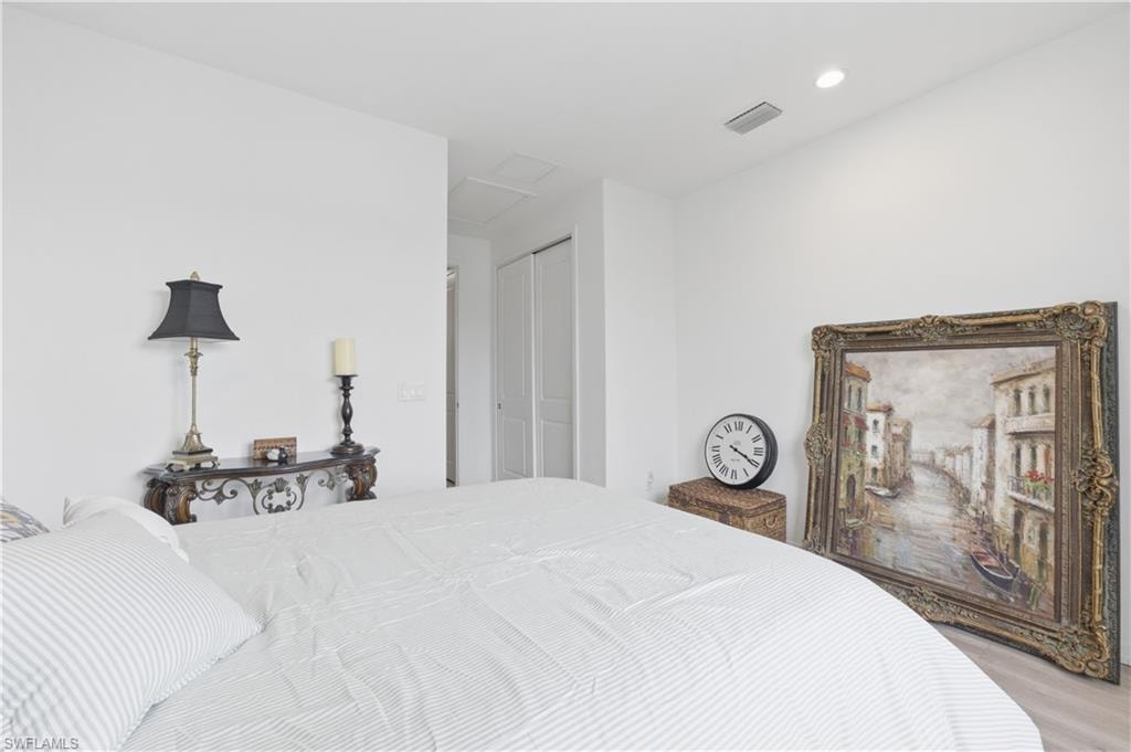 Bedroom with a closet, wood finished floors, and recessed lighting