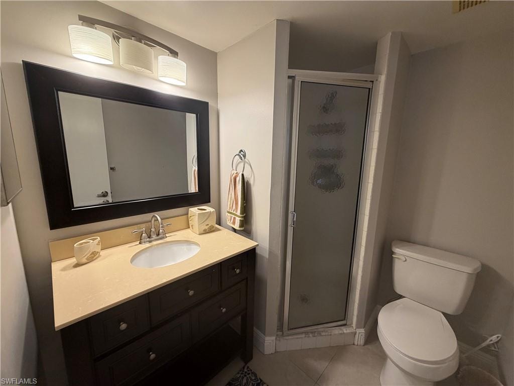 Bathroom with a shower stall, vanity, and light tile patterned floors