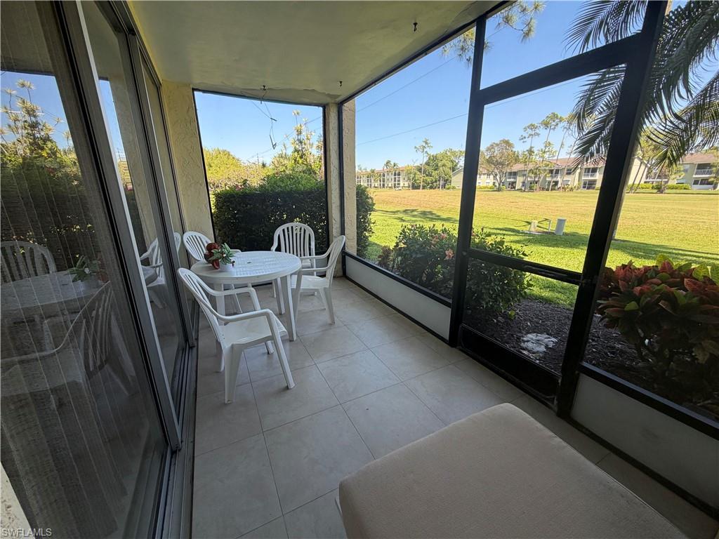 Sunroom / solarium with tile patterned flooring and expansive windows