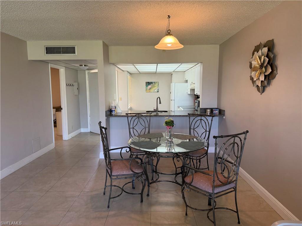 Dining space featuring a textured ceiling and light tile patterned floors