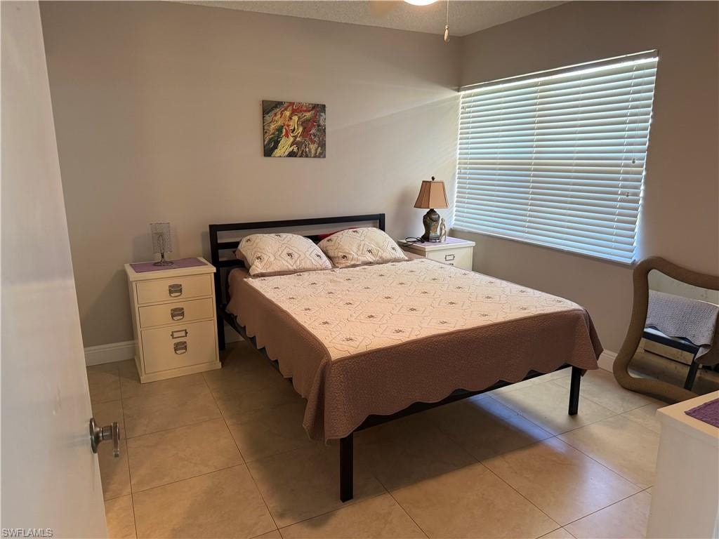 Bedroom with light tile patterned flooring and a textured ceiling