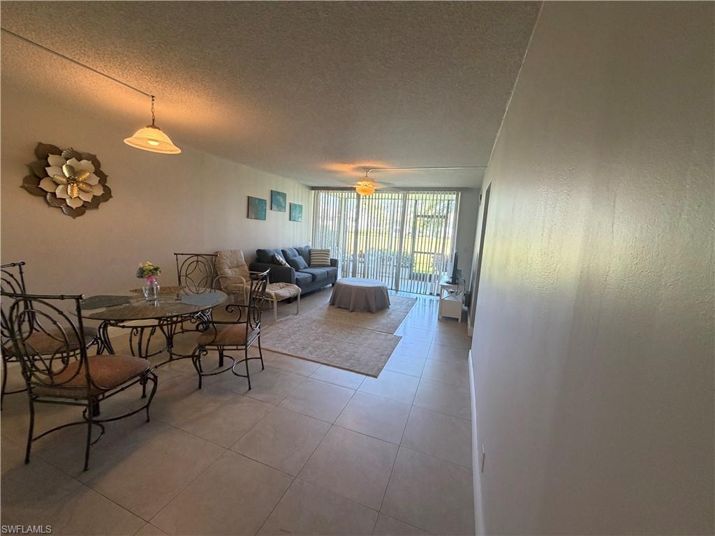 Living area featuring expansive windows, a textured ceiling, and light tile patterned flooring