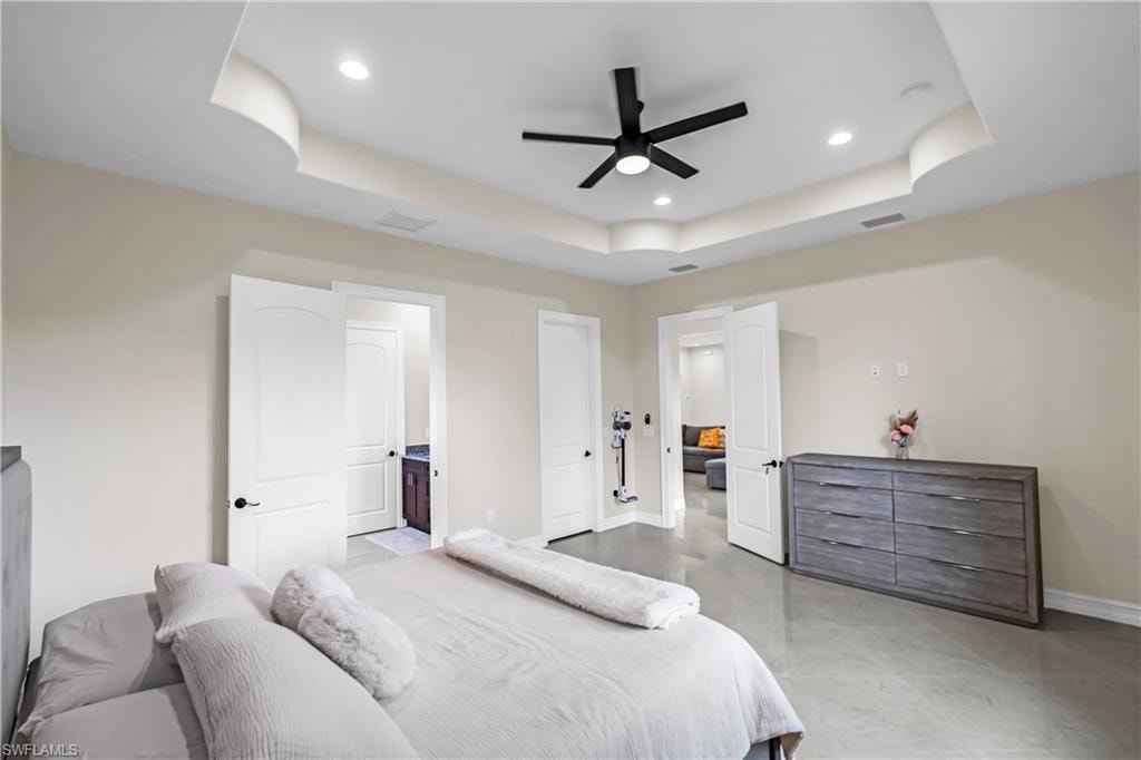 Recessed lighting and a contemporary black ceiling fan complement the tray ceiling