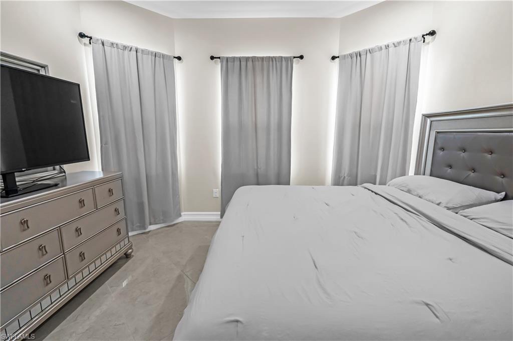 Corner windows with light gray drapery and dark-finish rods