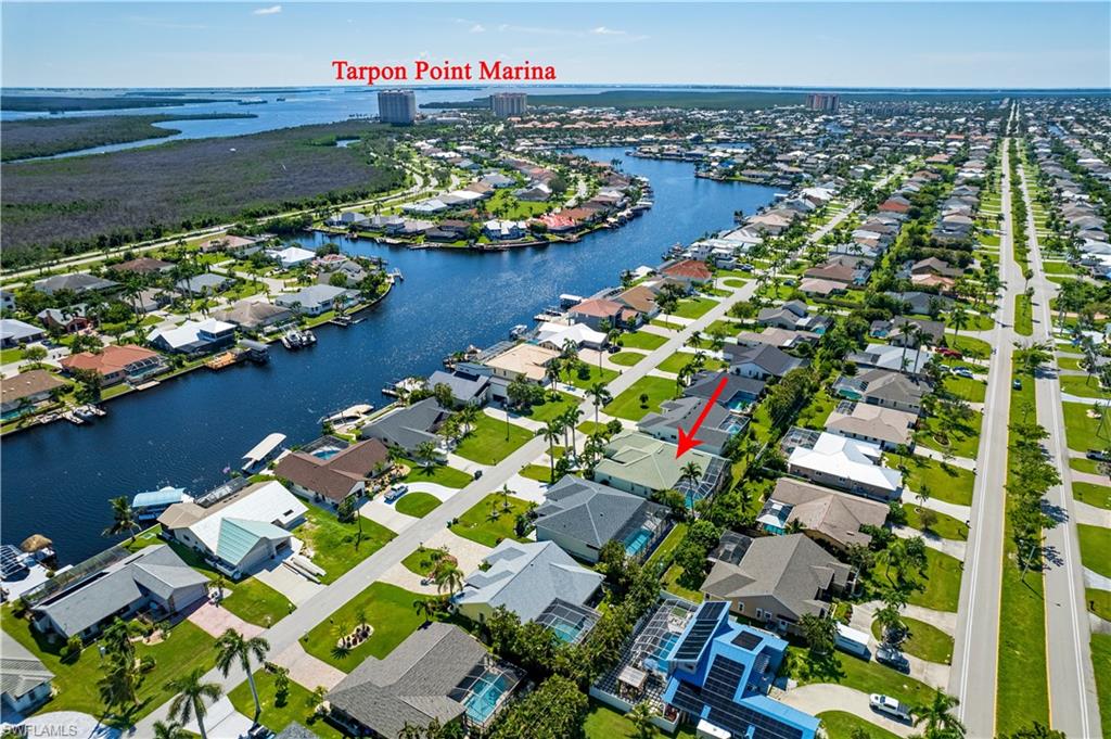 Aerial view of property and surrounding area featuring a large body of water and nearby suburban area