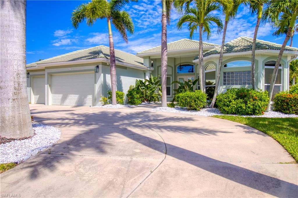 View of front of house featuring a garage, stucco siding, concrete driveway, and a tiled roof