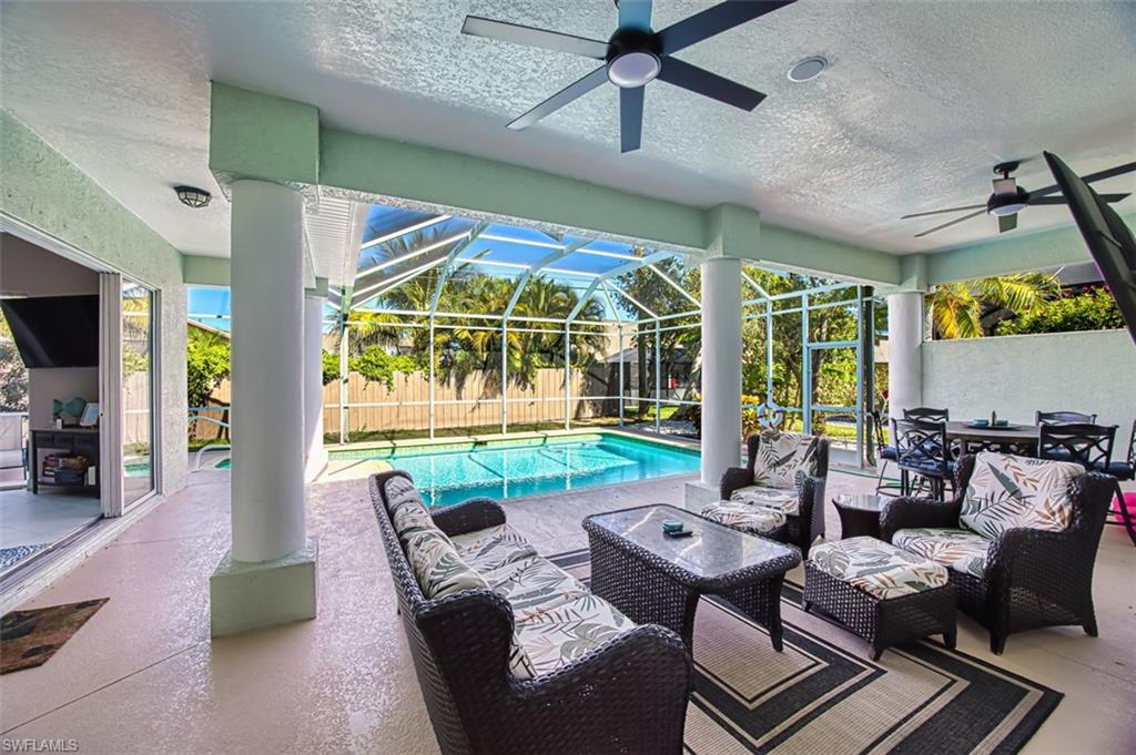 View of pool with patio surround, a fenced backyard, outdoor lounge area, a lanai, and a sunroom