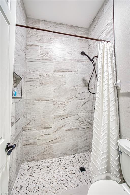 Bathroom with a shower stall and toilet