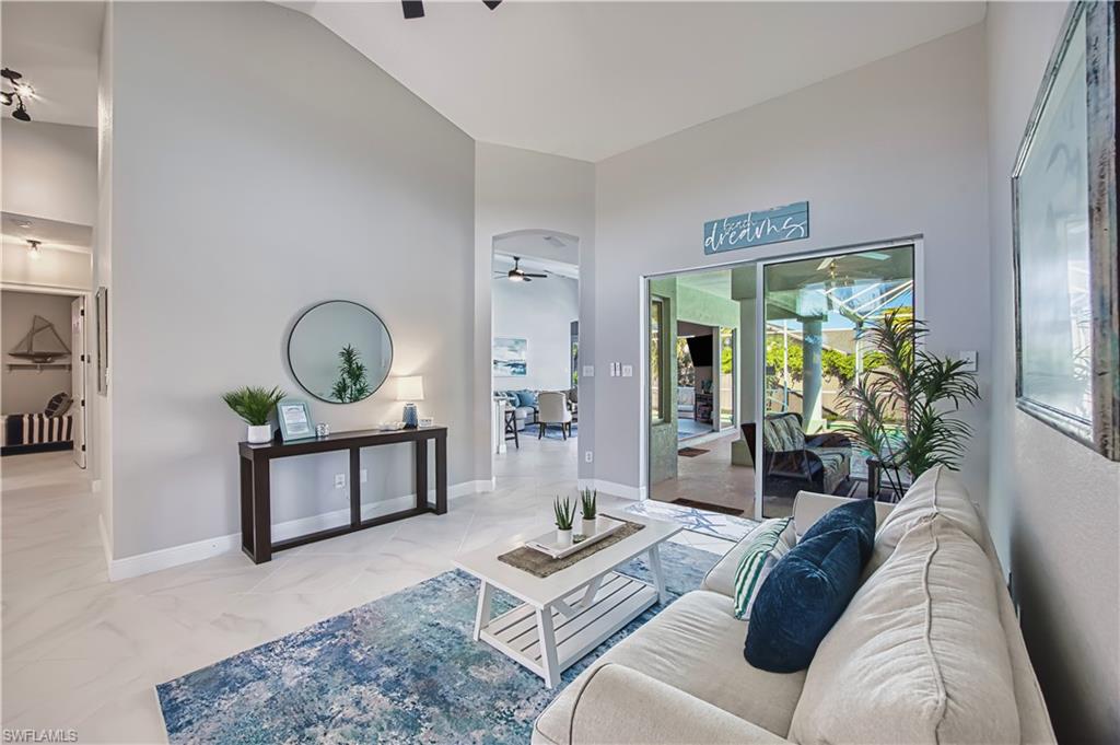 Living room with light marble finish floors, vaulted ceiling, and ceiling fan