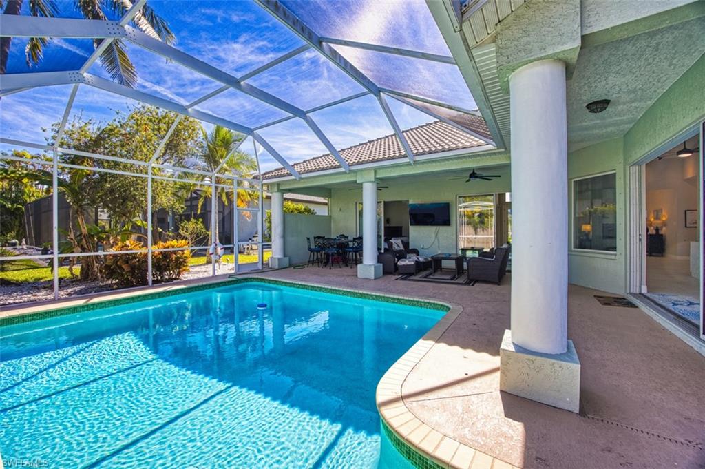 Outdoor pool featuring an outdoor living space, a lanai, a patio area, and a sunroom