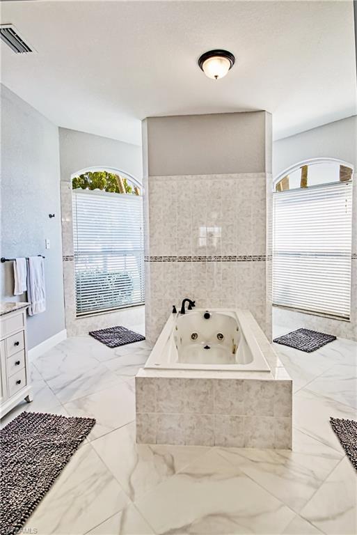 Full bath with vanity and a whirlpool tub