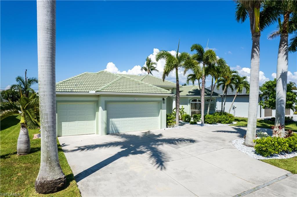 Single story home with an attached garage, stucco siding, driveway, and a tiled roof
