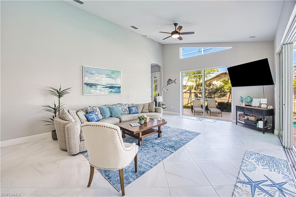 Living room with arched walkways, lofted ceiling, and a ceiling fan