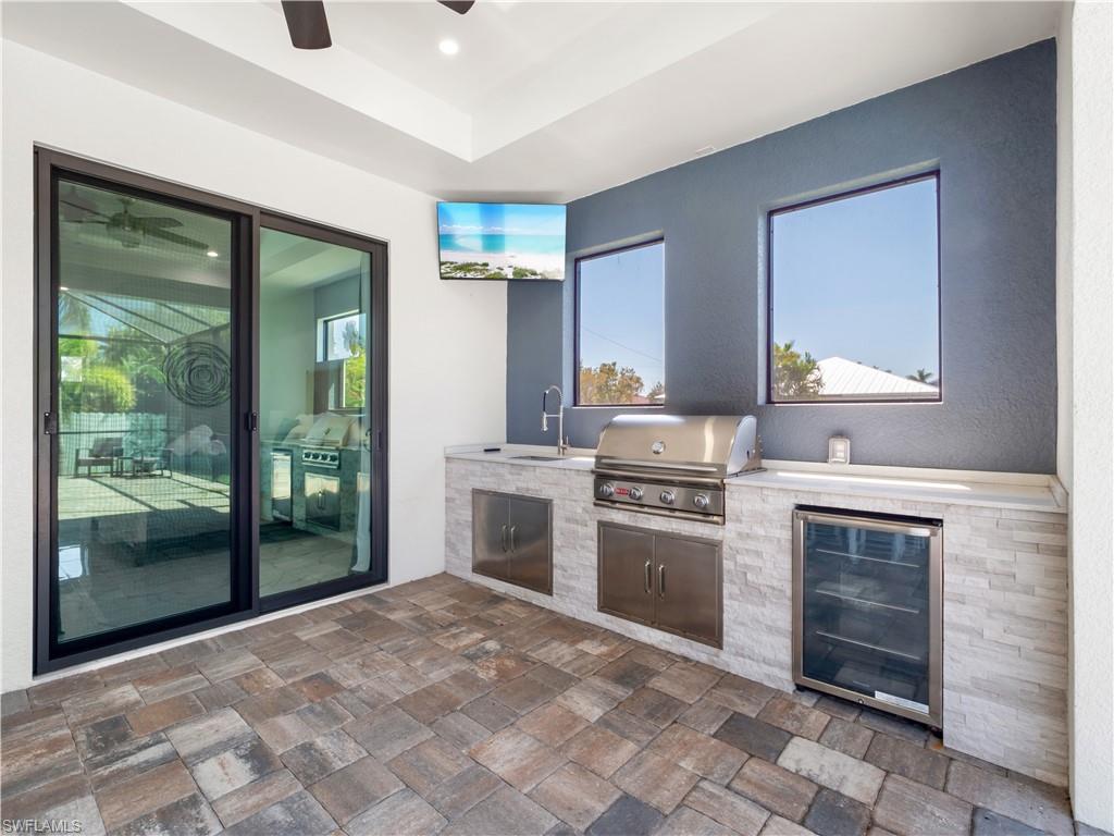 View of patio / terrace with an outdoor kitchen, wine cooler, and ceiling fan
