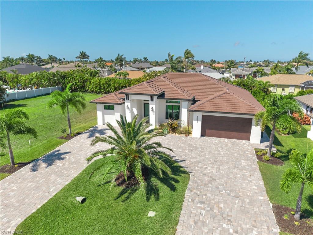 Mediterranean / spanish-style home with an attached garage, a front lawn, stucco siding, driveway, and a residential view