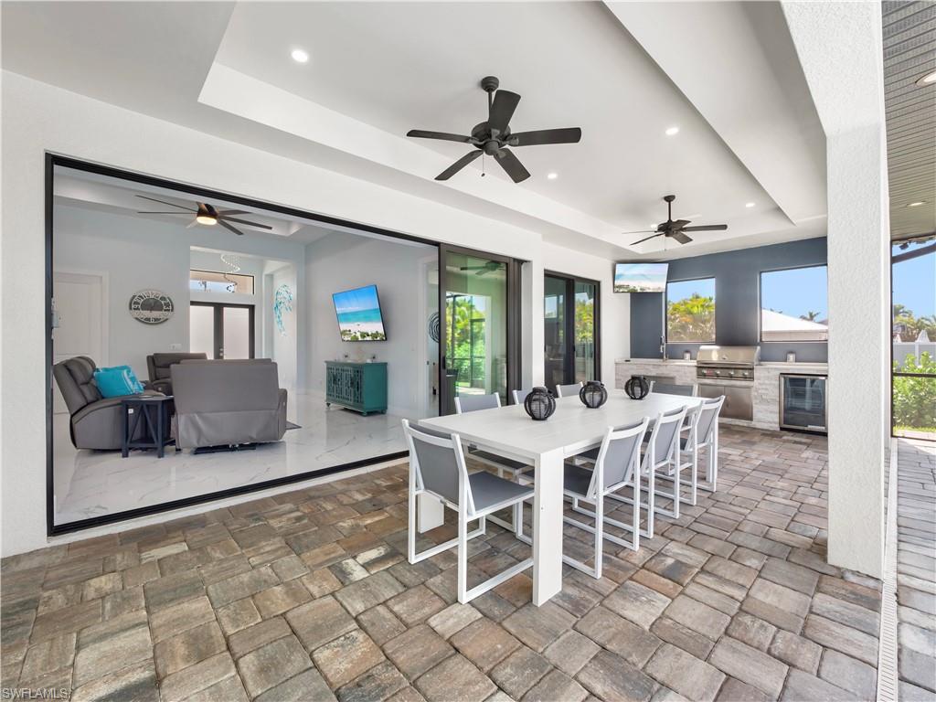 View of patio / terrace with an outdoor kitchen / dining area, french doors, beverage cooler, and ceiling fan