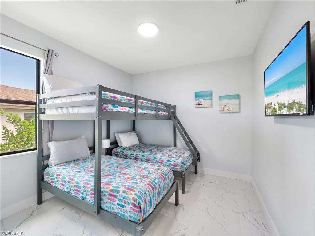 Bedroom with multiple windows and light marble finish floors