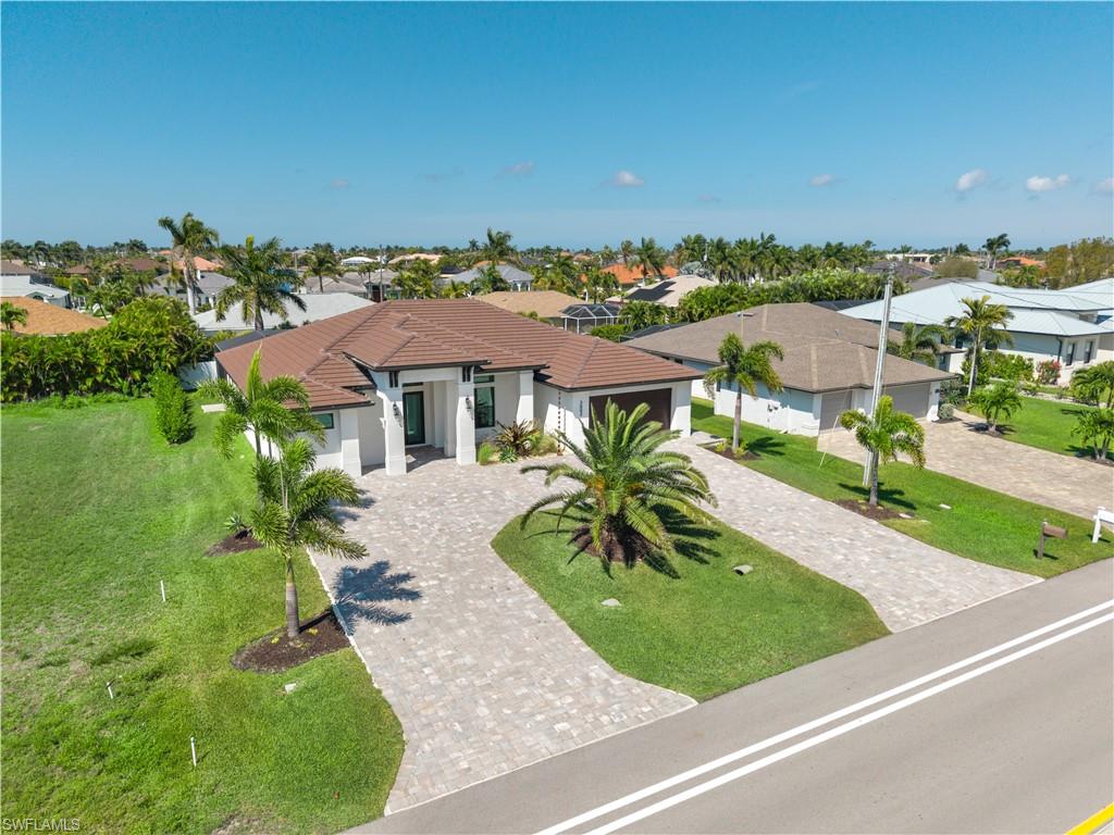 Mediterranean / spanish-style house with a front lawn, decorative driveway, stucco siding, a residential view, and a garage