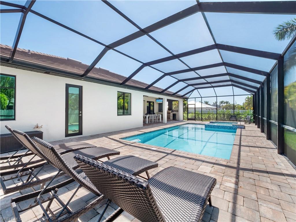 Integrated pool / spa featuring a sunroom, a patio area, and a lanai