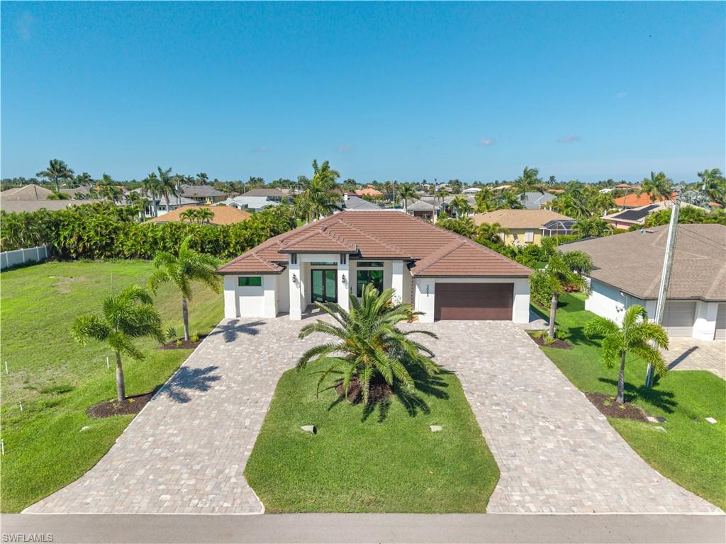 Mediterranean / spanish house with an attached garage, stucco siding, a residential view, and decorative driveway