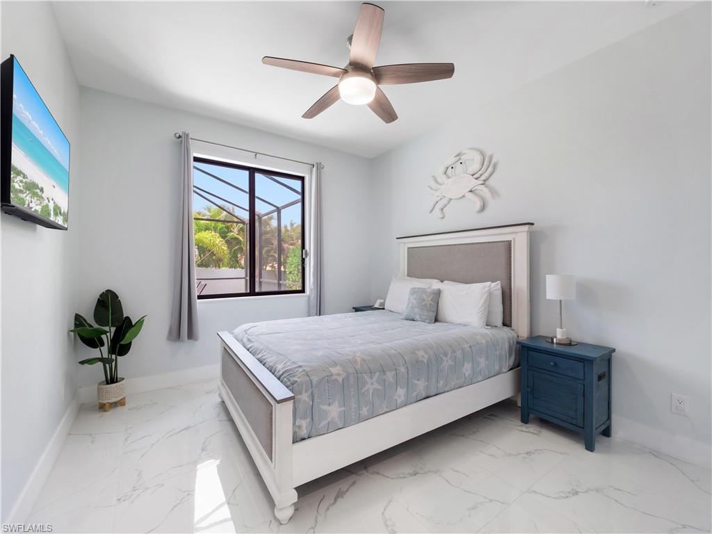 Bedroom featuring light marble finish floors and ceiling fan