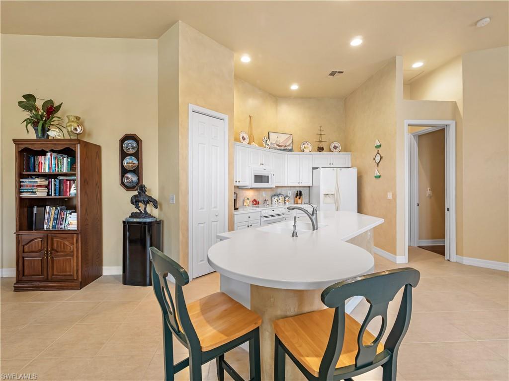 Dining space with light tile patterned floors and recessed lighting