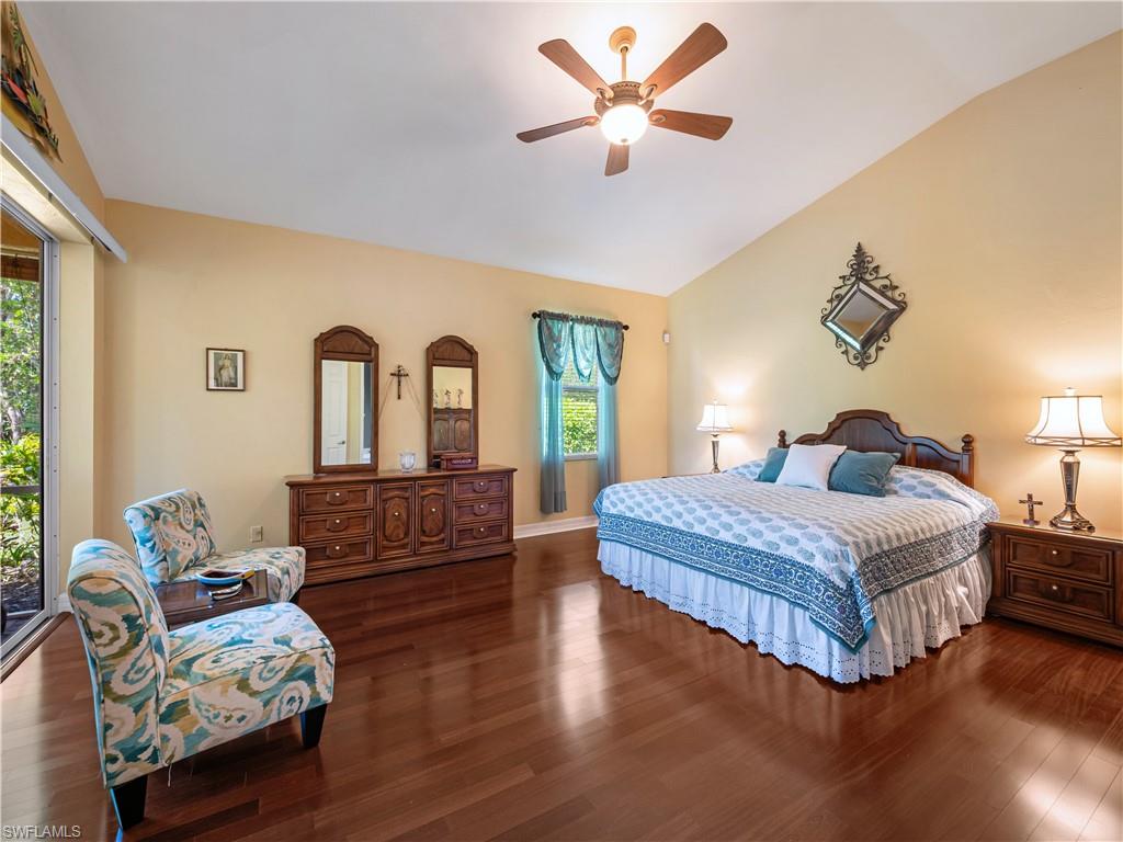 Bedroom featuring dark wood finished floors, lofted ceiling, and ceiling fan