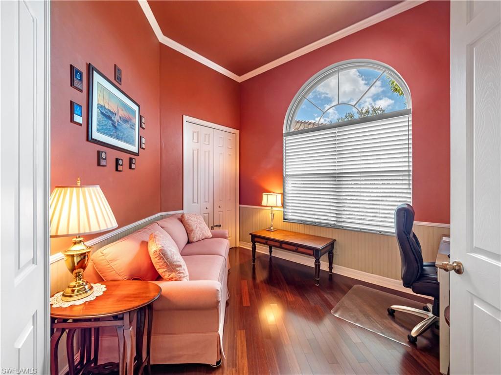 Office space with dark wood-type flooring, wainscoting, and ornamental molding