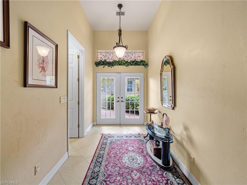 Foyer featuring french doors and light tile patterned floors