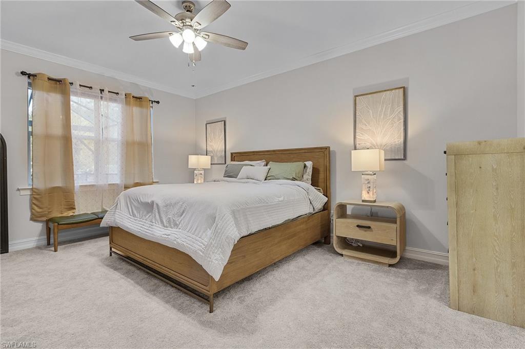 Bedroom with ceiling fan, carpet floors, and ornamental molding