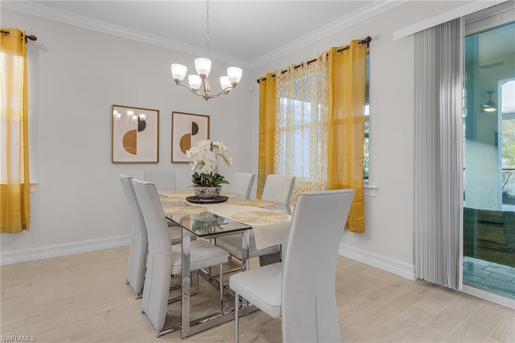 Dining space featuring light wood-type flooring, ornamental molding, and a chandelier