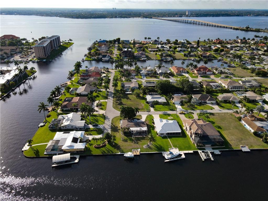 Aerial perspective of suburban area with a large body of water and a notable bridge