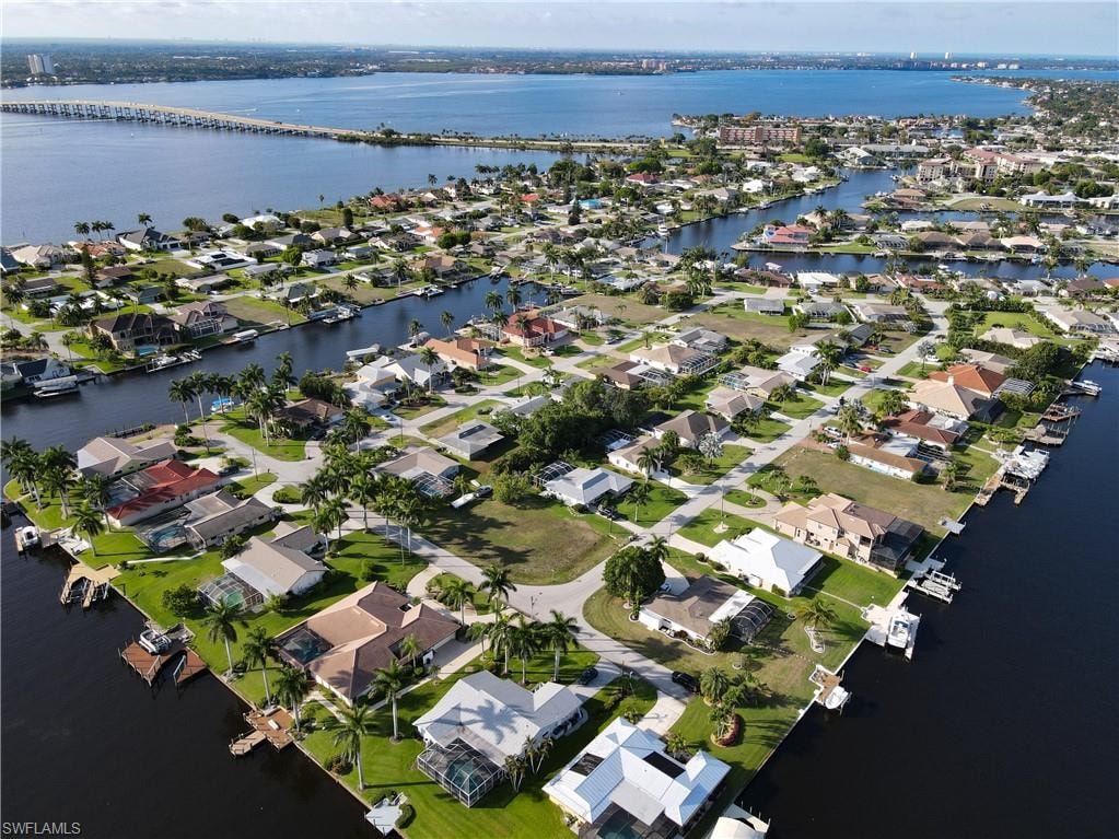 Aerial view of property and surrounding area featuring a nearby body of water and nearby suburban area