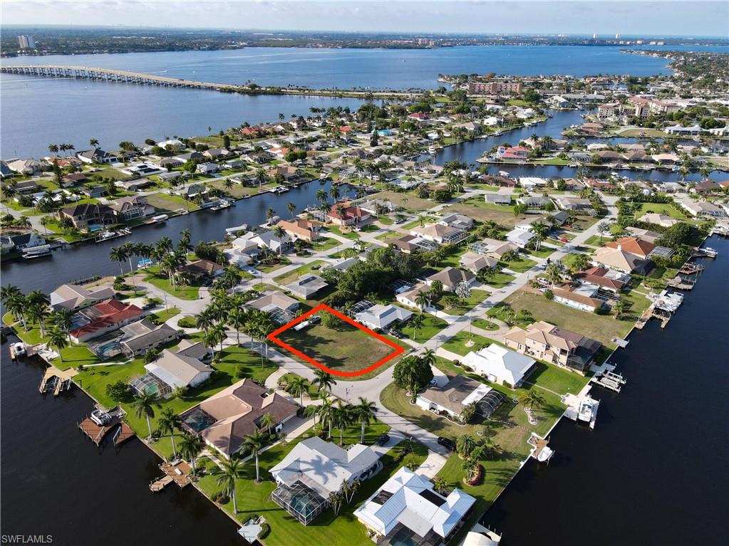 Aerial view of property's location with a large body of water, nearby suburban area, and property boundaries highlighted